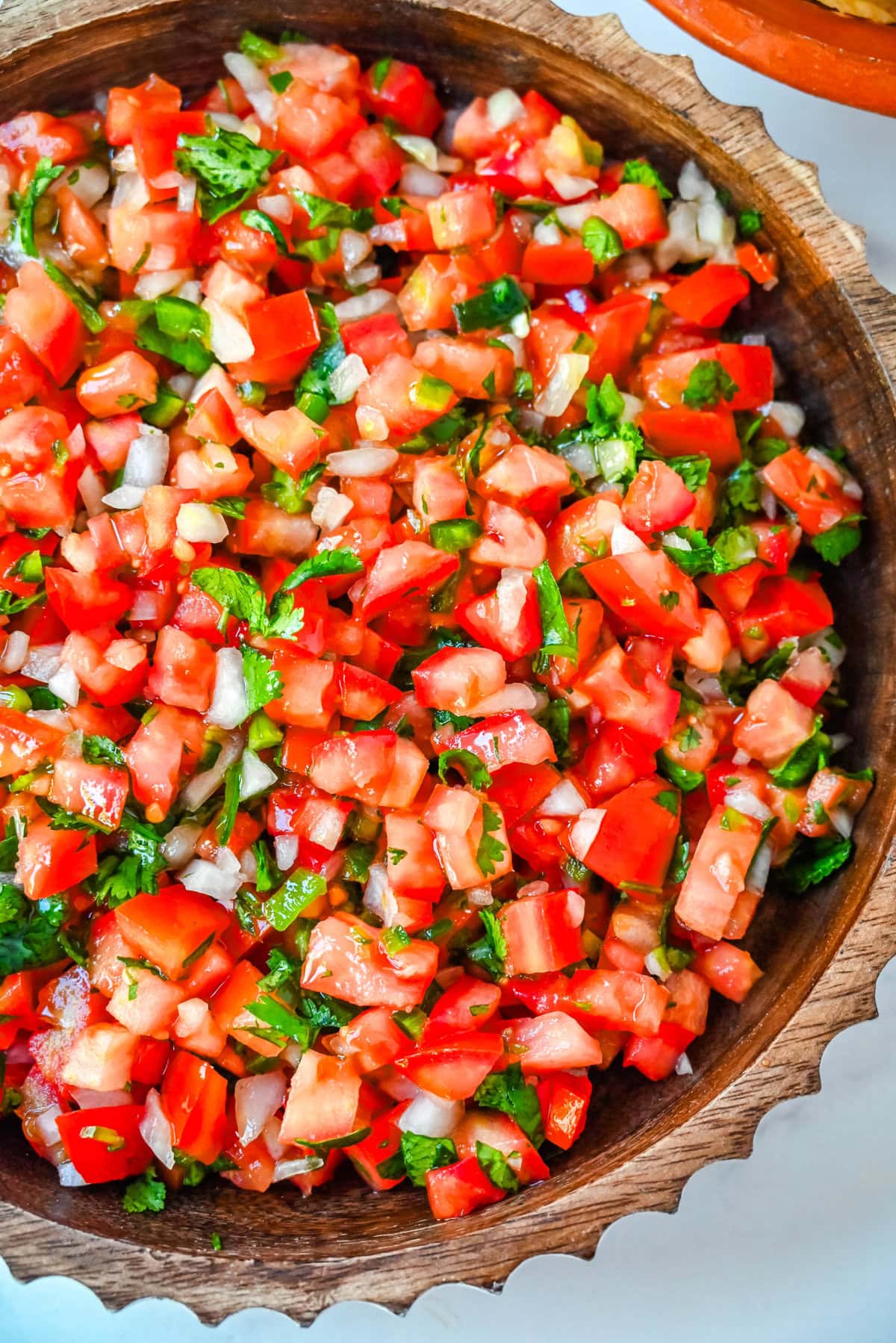 How to make fresh homemade pico de gallo made with the freshest ingredients -- fresh tomatoes, onion, cilantro, jalapeños, and lime juice. It is delicious on tacos, burritos, grilled meats, or as a simple fresh salsa with tortilla chips. It is super easy to whip up and is made with only six ingredients. 