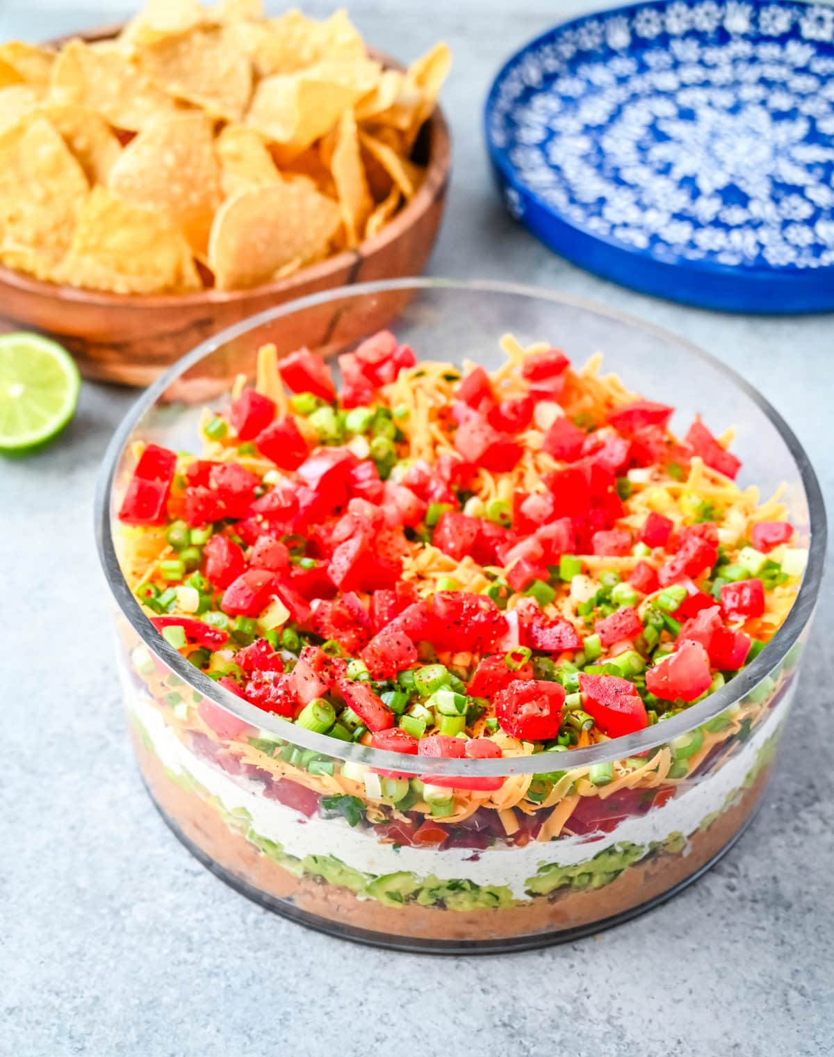 Seven-layer dip is a colorful, Tex-Mex-inspired appetizer featuring layers of refried beans, guacamole, seasoned sour cream, salsa, shredded cheese, fresh tomatoes, and sliced black olives. It’s popular because it’s easy to make, makes a stunning presentation, is delicious, and always a hit at parties or game-day gatherings. Whether you’re hosting a Super Bowl watch party or a casual family get-together, a classic 7 layer dip is guaranteed to impress.