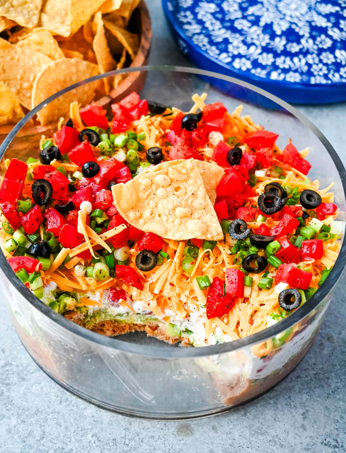 Seven-layer dip is a colorful, Tex-Mex-inspired appetizer featuring layers of refried beans, guacamole, seasoned sour cream, salsa, shredded cheese, fresh tomatoes, and sliced black olives. It’s popular because it’s easy to make, makes a stunning presentation, is delicious, and always a hit at parties or game-day gatherings. Whether you’re hosting a Super Bowl watch party or a casual family get-together, a classic 7 layer dip is guaranteed to impress.