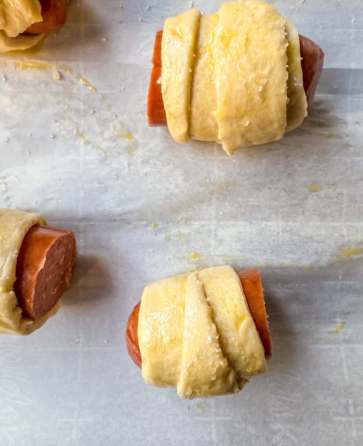 Wrapping hot dogs in crescent roll dough to make pigs in a blanket