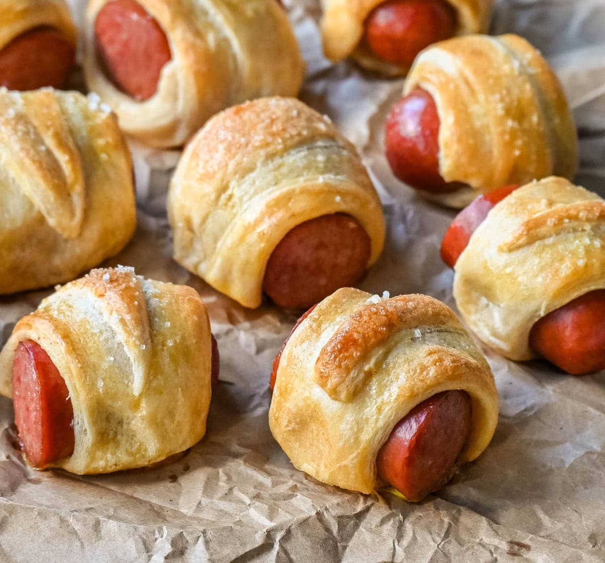 These Pigs in a Blanket are a classic, crowd-pleasing appetizer with juicy hot dogs wrapped in flaky crescent dough and baked until golden. These crescent roll hot dogs are so easy to prepare and you can even customize them into pretzel dogs. This is such an easy party appetizer to whip up in less than 30 minutes.