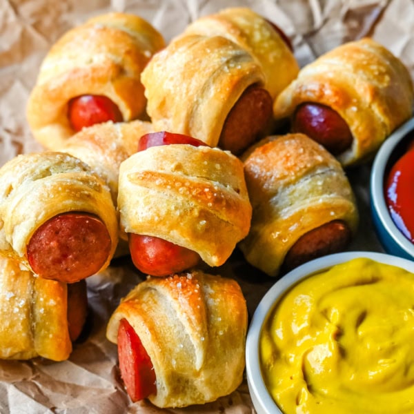 These Pigs in a Blanket are a classic, crowd-pleasing appetizer with juicy hot dogs wrapped in flaky crescent dough and baked until golden. These crescent roll hot dogs are so easy to prepare and you can even customize them into pretzel dogs. This is such an easy party appetizer to whip up in less than 30 minutes.