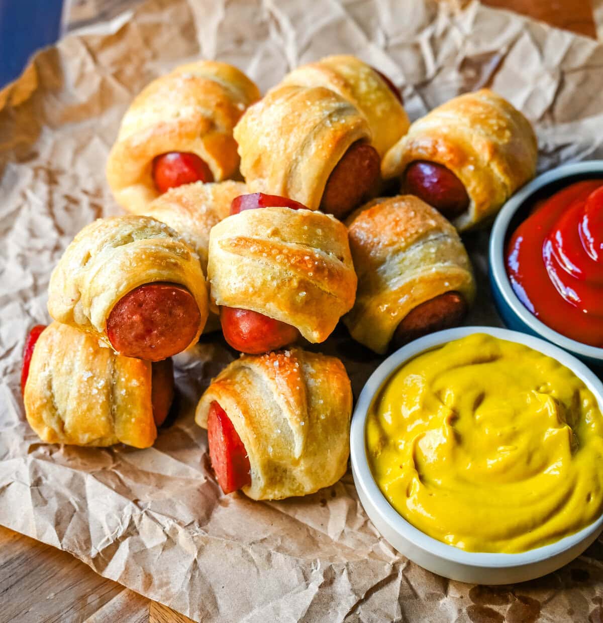 These Pigs in a Blanket are a classic, crowd-pleasing appetizer with juicy hot dogs wrapped in flaky crescent dough and baked until golden. These crescent roll hot dogs are so easy to prepare and you can even customize them into pretzel dogs. This is such an easy party appetizer to whip up in less than 30 minutes.