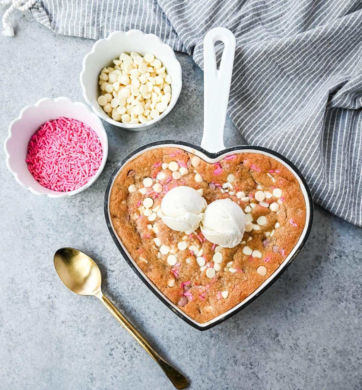 Valentine's Day Heart Skillet Cookie. Soft, chewy skillet cookie recipe filled with white chocolate chips, pink sprinkles, and any of your favorite festive additions such as Valentine's Day M&M's and ruby chocolate. Top it with vanilla ice cream and have the perfect Valentine's Day dessert.