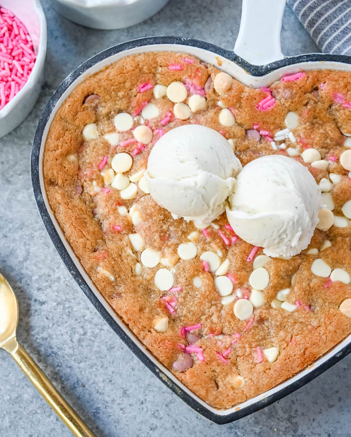 Valentine's Day Heart Skillet Cookie. Soft, chewy skillet cookie recipe filled with white chocolate chips, pink sprinkles, and any of your favorite festive additions such as Valentine's Day M&M's and ruby chocolate. Top it with vanilla ice cream and have the perfect Valentine's Day dessert.