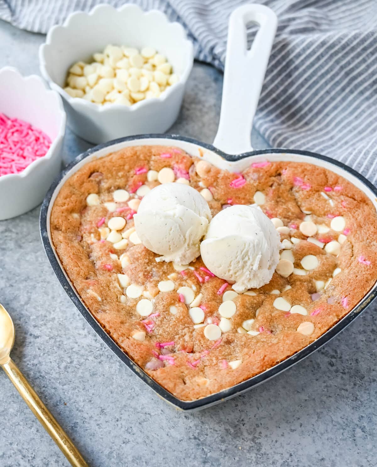 Valentine's Day Heart Skillet Cookie. Soft, chewy skillet cookie recipe filled with white chocolate chips, pink sprinkles, and any of your favorite festive additions such as Valentine's Day M&M's and ruby chocolate. Top it with vanilla ice cream and have the perfect Valentine's Day dessert.