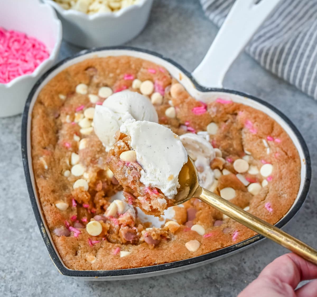 Valentine's Day Heart Skillet Cookie. Soft, chewy skillet cookie recipe filled with white chocolate chips, pink sprinkles, and any of your favorite festive additions such as Valentine's Day M&M's and ruby chocolate. Top it with vanilla ice cream and have the perfect Valentine's Day dessert.