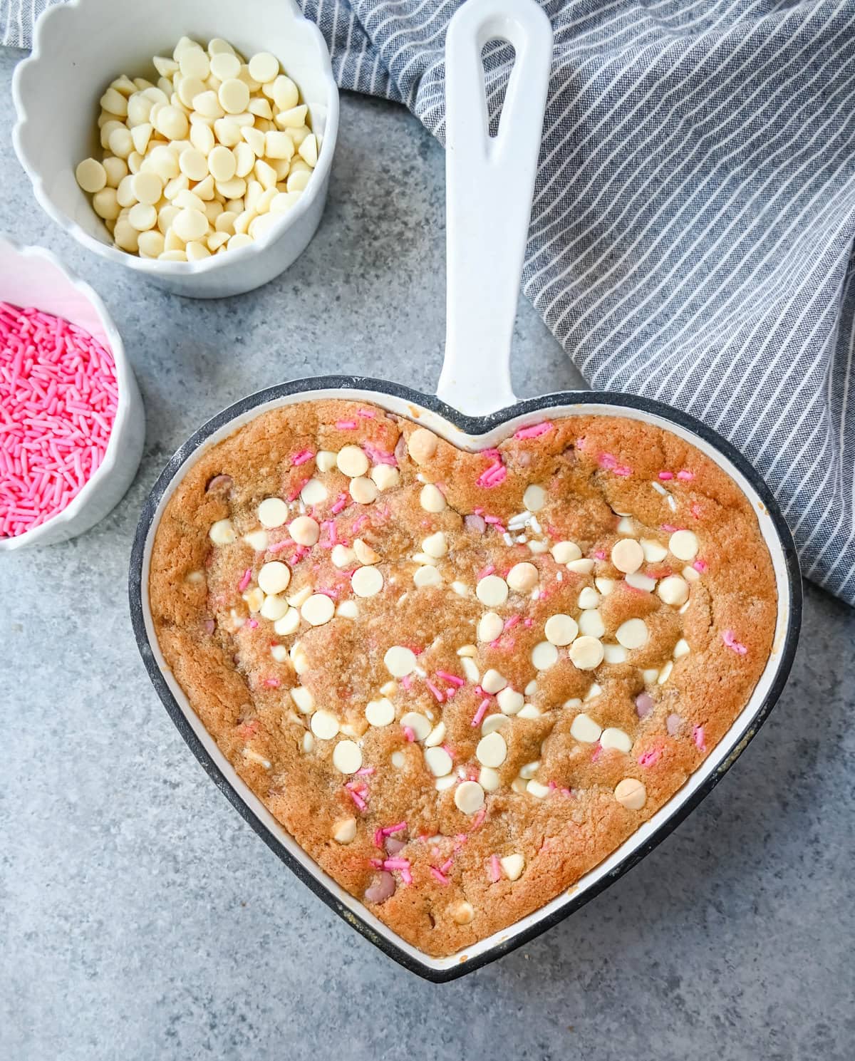 Valentine's Day Heart Skillet Cookie. Soft, chewy skillet cookie recipe filled with white chocolate chips, pink sprinkles, and any of your favorite festive additions such as Valentine's Day M&M's and ruby chocolate. Top it with vanilla ice cream and have the perfect Valentine's Day dessert.