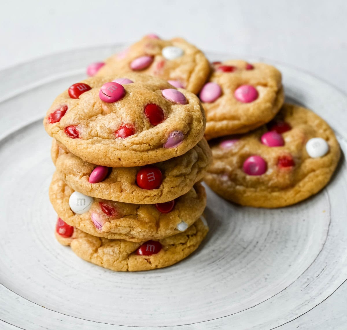 How to make the perfect Valentine's Day cookies. These soft and chewy Valentine's M&M Cookies have pops of pink, red, and white M&M's to make them not only delicious but festive and fun as well. You will love these Valentine's cookies!