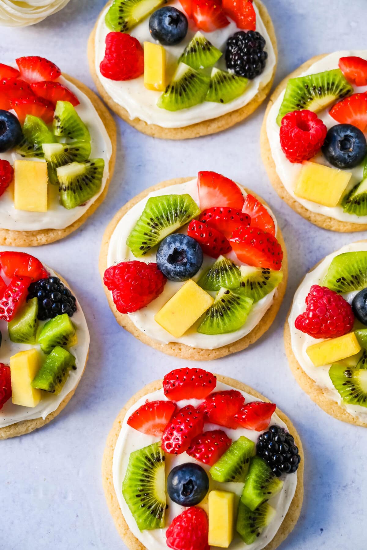 These Fruit Pizza Cookies are made with soft, chewy, buttery sugar cookies topped with a sweet cream cheese frosting and fresh fruit. These Sugar Cookie Fruit Pizzas are always a huge hit!