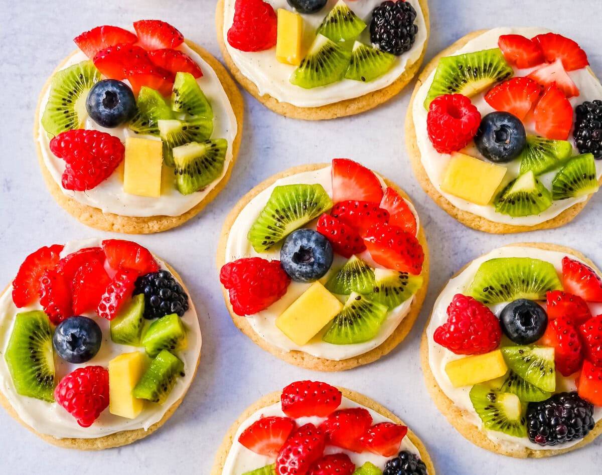 These Fruit Pizza Cookies are made with soft, chewy, buttery sugar cookies topped with a sweet cream cheese frosting and fresh fruit. These Sugar Cookie Fruit Pizzas are always a huge hit!