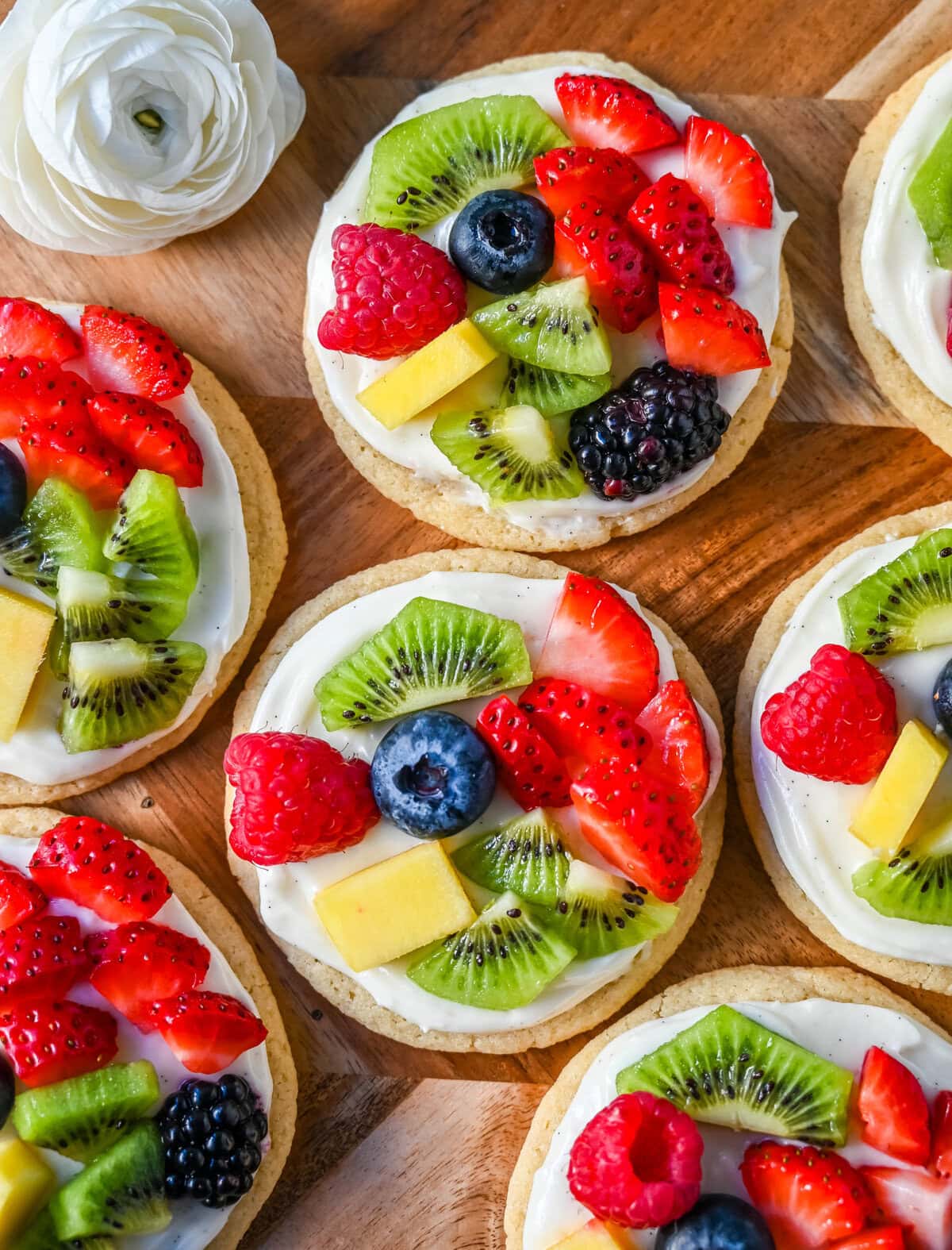 These Fruit Pizza Cookies are made with soft, chewy, buttery sugar cookies topped with a sweet cream cheese frosting and fresh fruit. These Sugar Cookie Fruit Pizzas are always a huge hit!